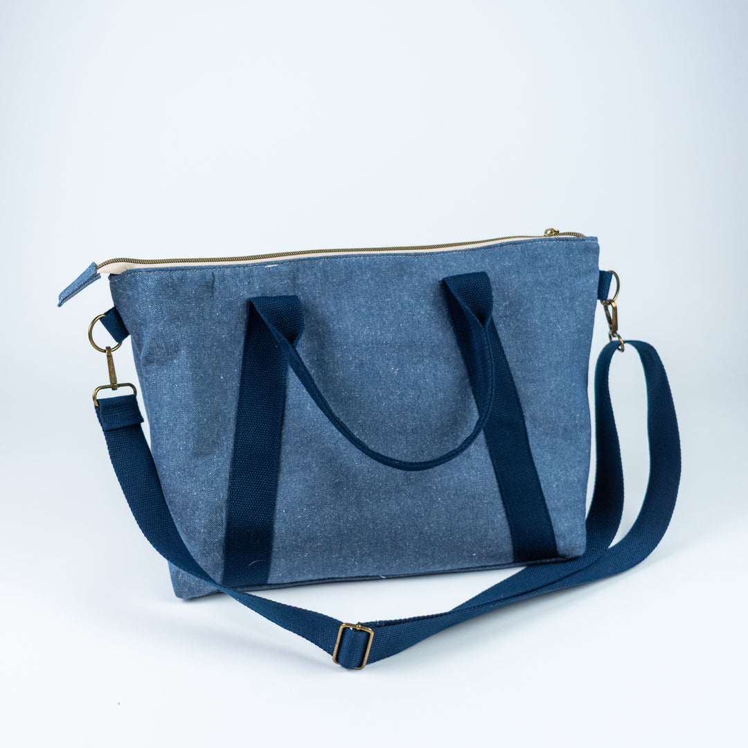 Blue denim bag with a shoulder strap on a white background