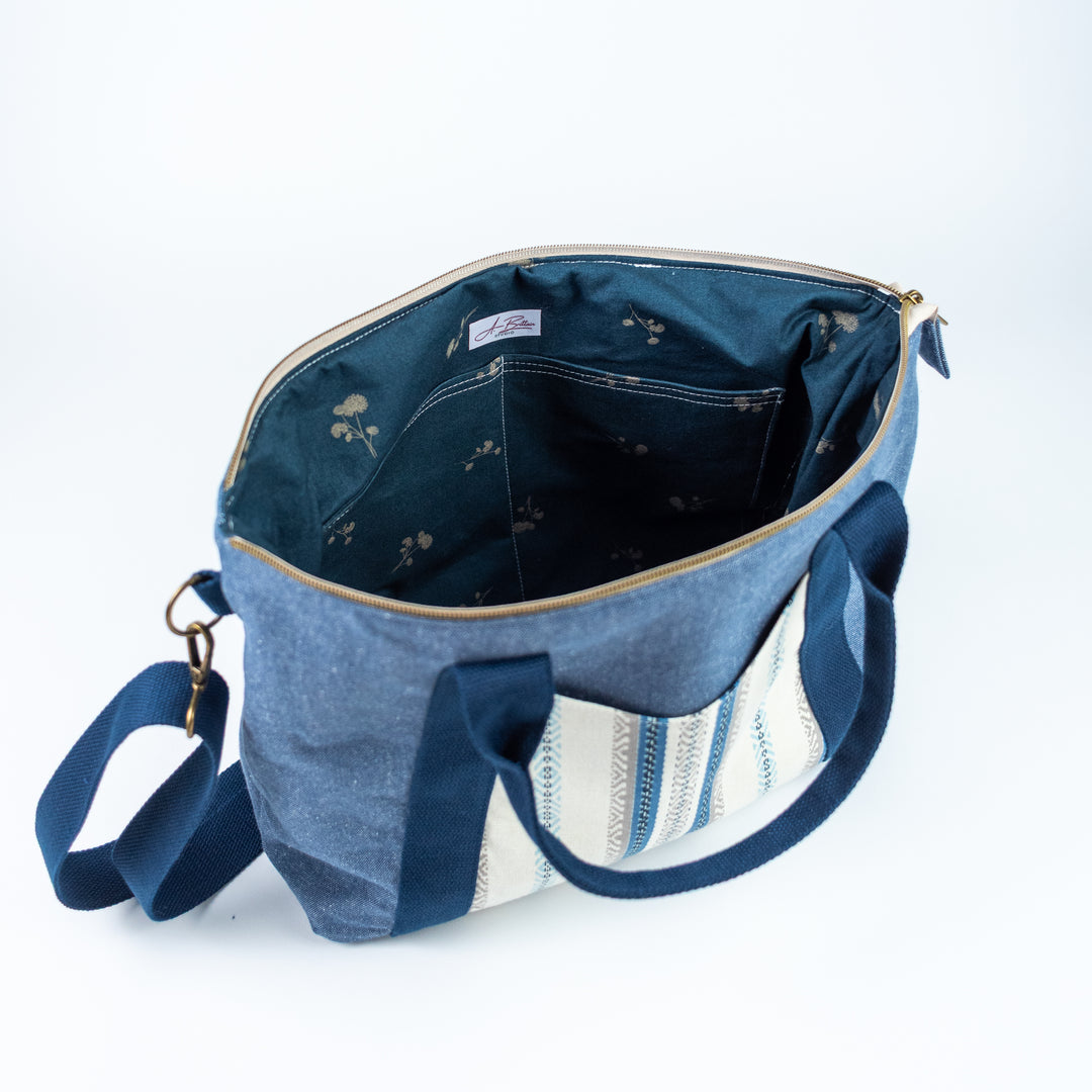 Blue denim bag with floral patterns on a white background