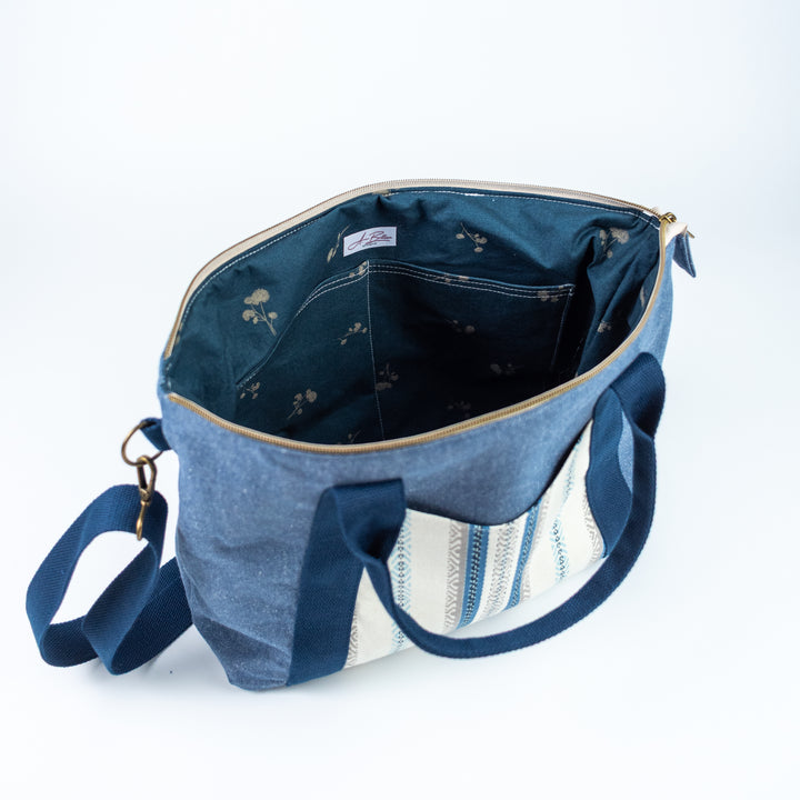 Blue denim bag with floral patterns on a white background
