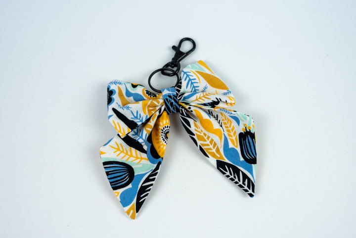 Fabric bow keychain with blue and yellow pattern on a white background
