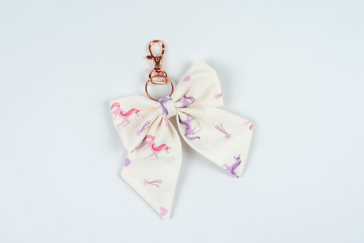 Bow-shaped keychain with a unicorn pattern on a white background