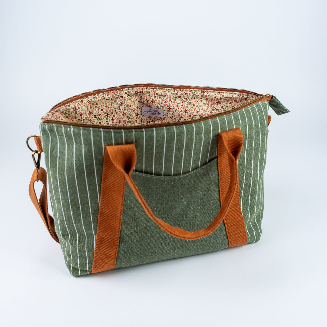 Green striped bag with brown handles and trim on a white background