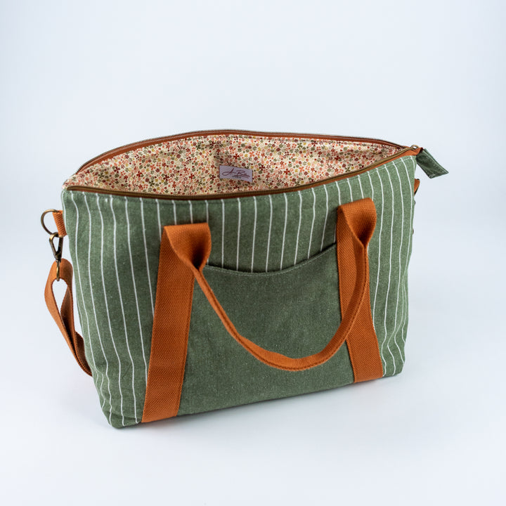 Green striped bag with brown handles and trim on a white background
